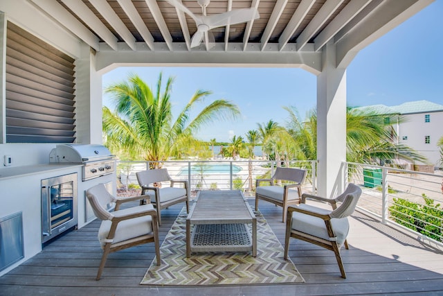 wooden deck featuring a grill, outdoor lounge area, and exterior kitchen