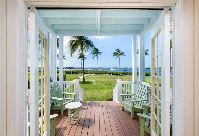 exterior space featuring a yard, a water view, and a porch