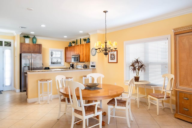 dining area with ornamental molding, a chandelier, and light tile patterned floors