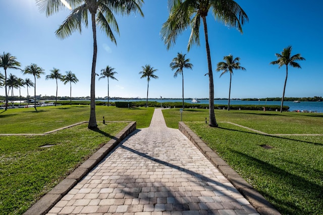 view of home's community with a lawn and a water view