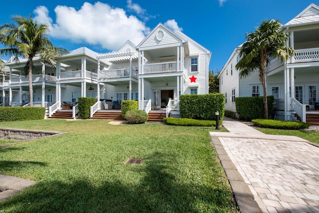 view of front facade featuring french doors, a pergola, and a front lawn