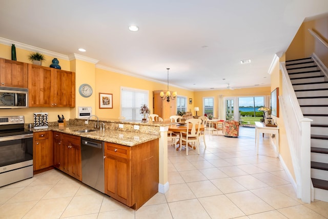 kitchen with sink, light tile patterned floors, appliances with stainless steel finishes, kitchen peninsula, and pendant lighting