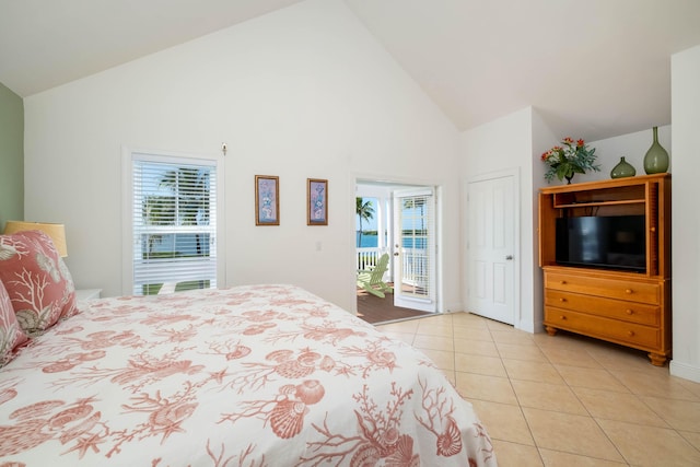 tiled bedroom featuring multiple windows, access to outside, and high vaulted ceiling