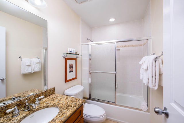 full bathroom featuring vanity, shower / bath combination with glass door, and toilet