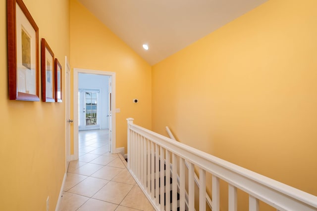 hallway with light tile patterned flooring and lofted ceiling