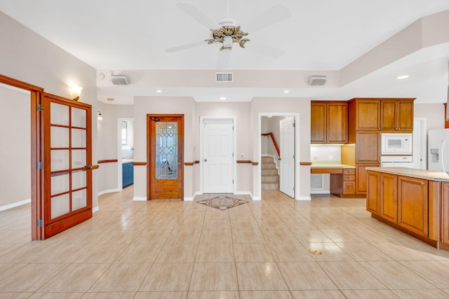 kitchen with visible vents, white appliances, brown cabinets, and light countertops