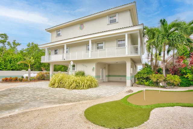 back of property with stucco siding and decorative driveway