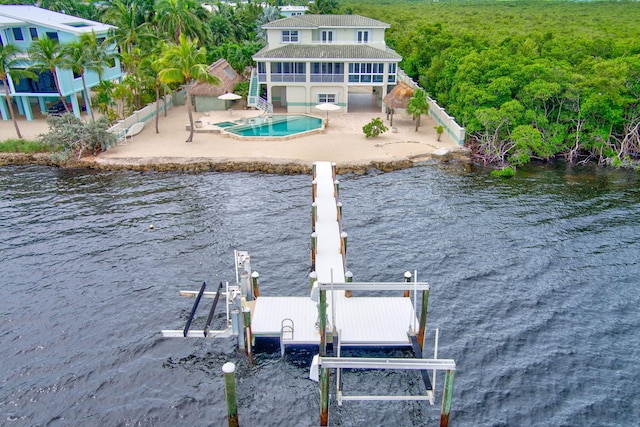 dock area with a water view, stairway, a patio area, boat lift, and an outdoor pool