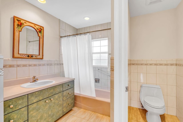 bathroom with tile walls, shower / bath combination with curtain, toilet, and tile patterned floors