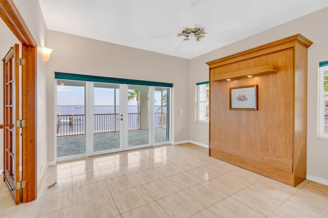 entryway with light tile patterned floors, a ceiling fan, baseboards, and french doors