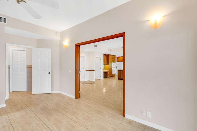 unfurnished room featuring light tile patterned floors, baseboards, visible vents, and ceiling fan