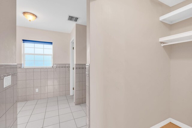 bathroom featuring tile walls, an enclosed shower, tile patterned flooring, and toilet