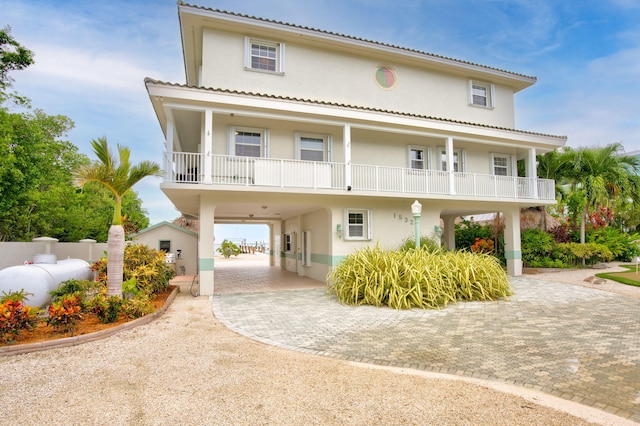 view of front of home with decorative driveway, covered porch, and stucco siding