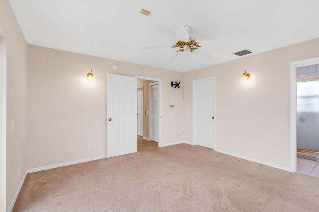 unfurnished room with visible vents, baseboards, light colored carpet, and a ceiling fan