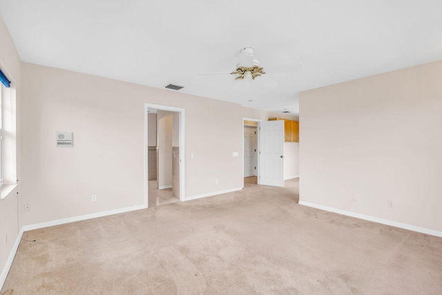 unfurnished room with light carpet, visible vents, ceiling fan, and baseboards