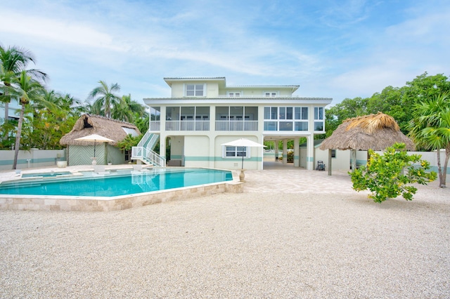 view of swimming pool with stairway, a patio area, a fenced in pool, and a sunroom