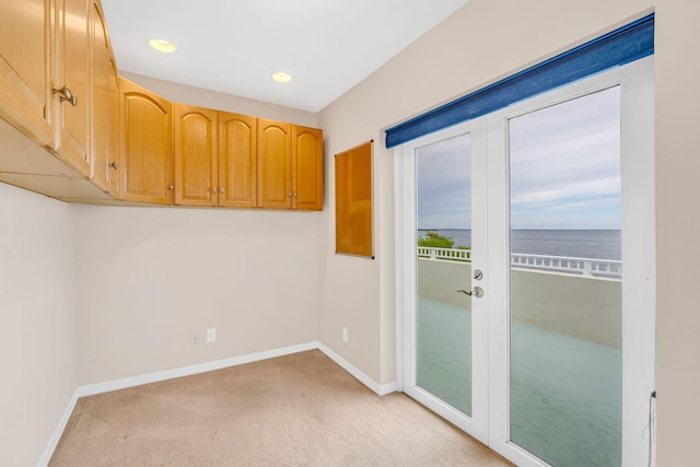 empty room featuring recessed lighting, baseboards, light carpet, and french doors