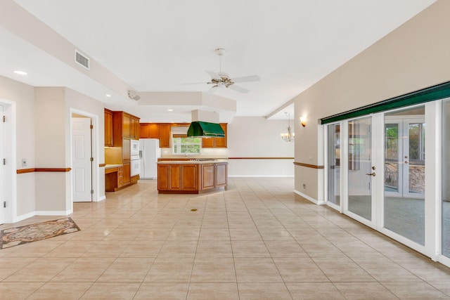 kitchen featuring visible vents, brown cabinets, white fridge with ice dispenser, light countertops, and extractor fan