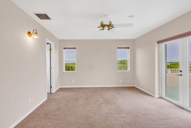 unfurnished room with baseboards, visible vents, ceiling fan, french doors, and light carpet