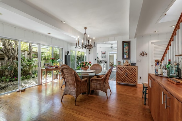 dining room featuring a chandelier, wood finished floors, and a decorative wall