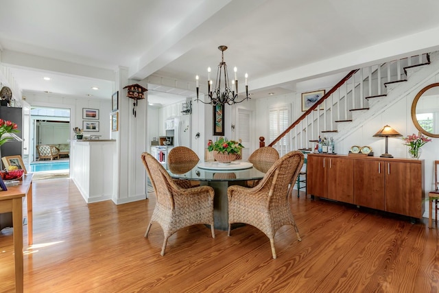 dining area with recessed lighting, a notable chandelier, stairway, light wood-type flooring, and beamed ceiling