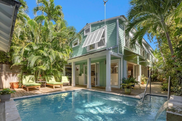 rear view of house with an outdoor pool