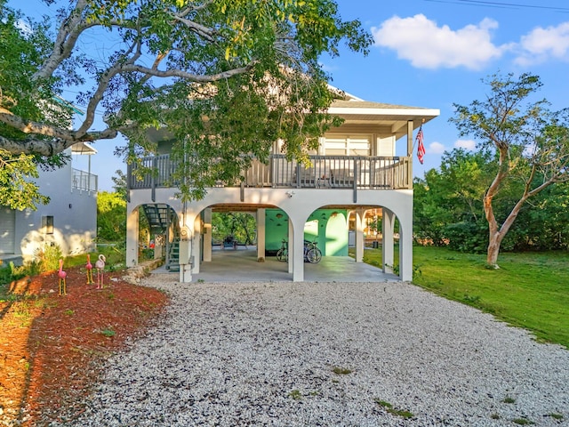 back of house featuring a carport and a yard