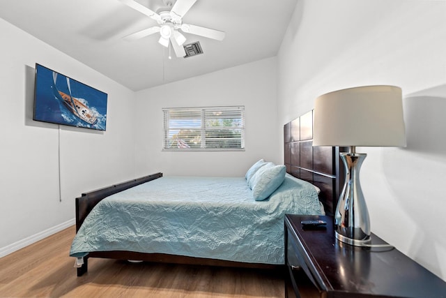 bedroom with ceiling fan, lofted ceiling, and hardwood / wood-style floors