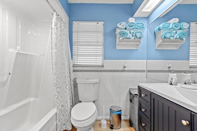 full bathroom featuring vanity, tile walls, shower / bathtub combination with curtain, and toilet