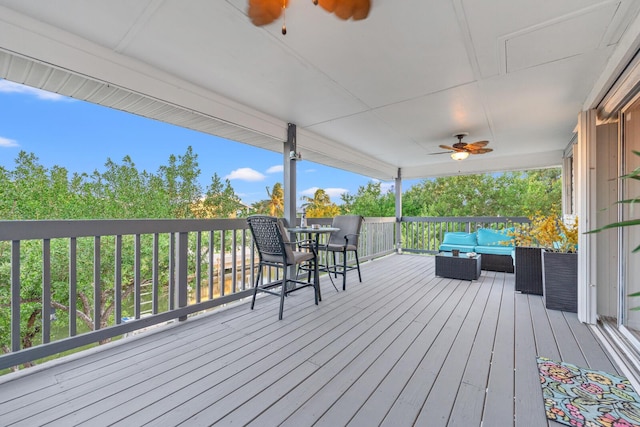 wooden terrace with an outdoor hangout area and ceiling fan