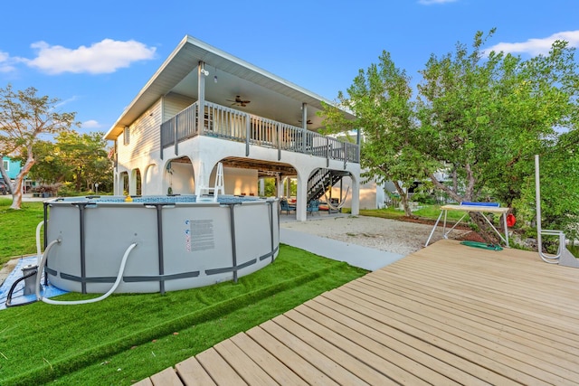 rear view of property with ceiling fan and a yard