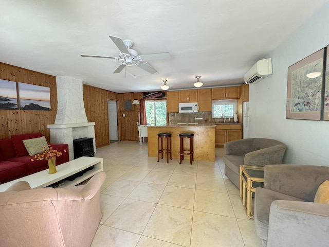 tiled living room featuring ceiling fan, sink, a wall mounted air conditioner, and wooden walls