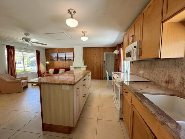 kitchen featuring light tile patterned flooring, a kitchen island, sink, ceiling fan, and white appliances