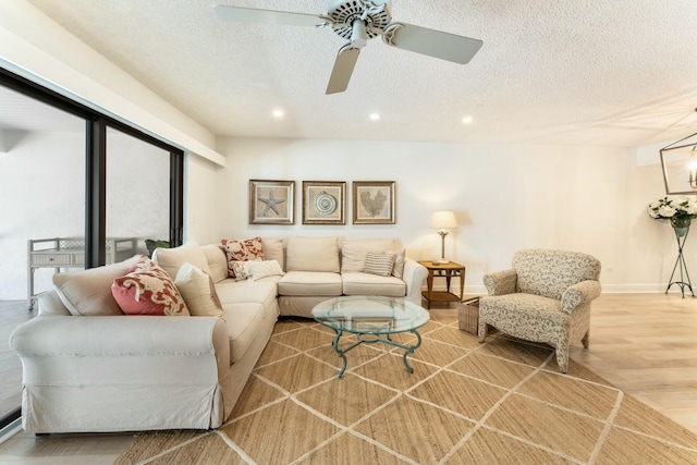 living room featuring ceiling fan, a textured ceiling, wood finished floors, and recessed lighting