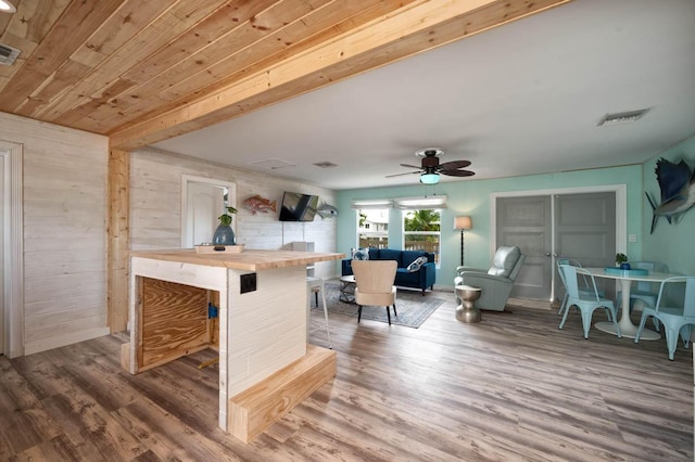 kitchen with a breakfast bar, butcher block countertops, hardwood / wood-style floors, and wooden ceiling