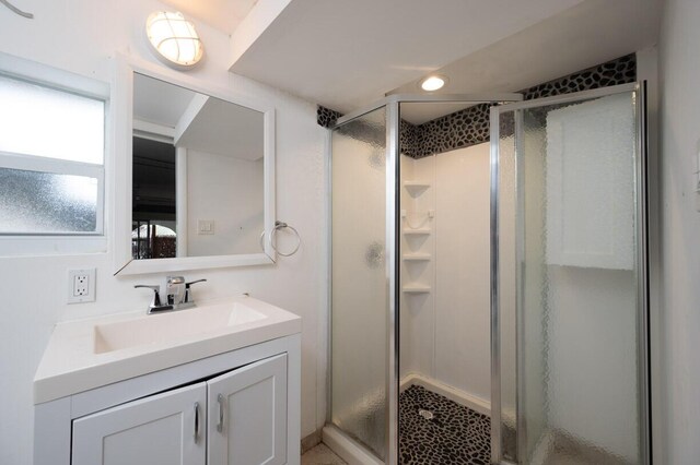 bathroom featuring vanity and a shower with door