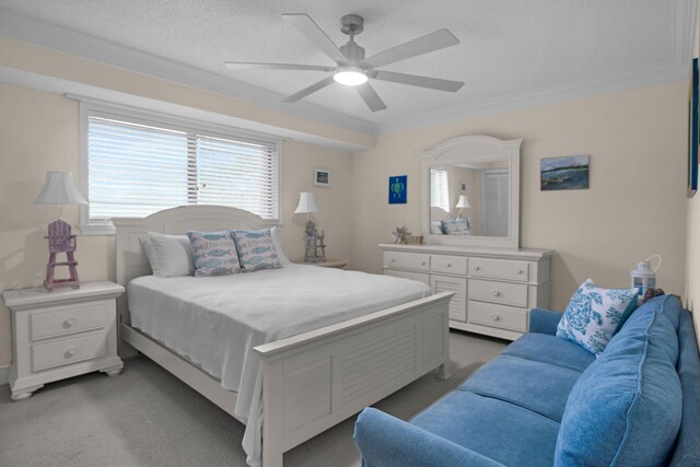 bedroom featuring ceiling fan, crown molding, a textured ceiling, and carpet flooring