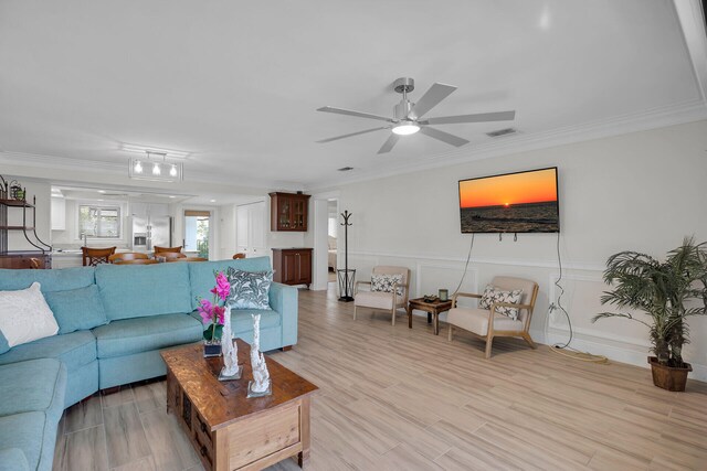 living room with crown molding, ceiling fan, and light hardwood / wood-style flooring