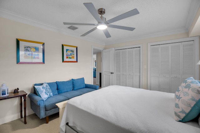 bedroom featuring two closets, ornamental molding, and carpet flooring