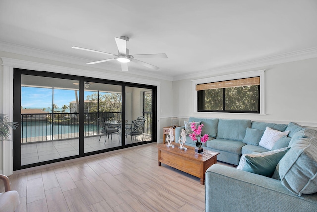 living room featuring a water view, ceiling fan, ornamental molding, and light wood-type flooring