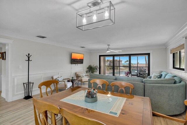 dining room with ornamental molding, ceiling fan, and light wood-type flooring