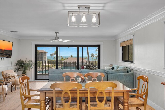 dining space with light hardwood / wood-style flooring, ornamental molding, and ceiling fan