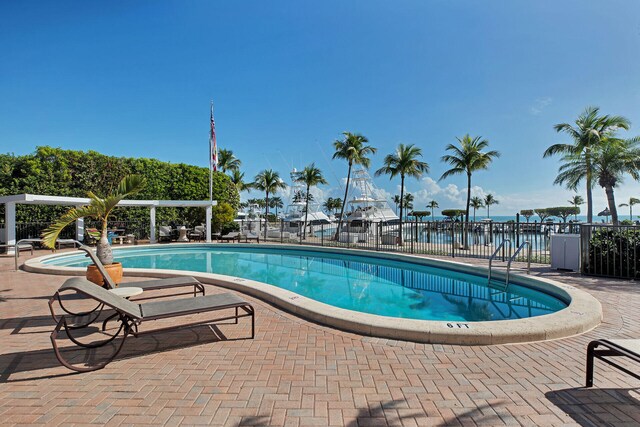 view of swimming pool featuring a water view and a patio area