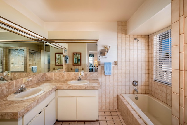 bathroom featuring tile patterned flooring, vanity, tiled shower / bath combo, and tile walls