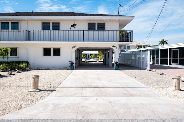 view of front facade with a carport and a balcony