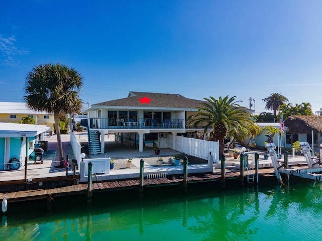 back of house with a water view and a patio