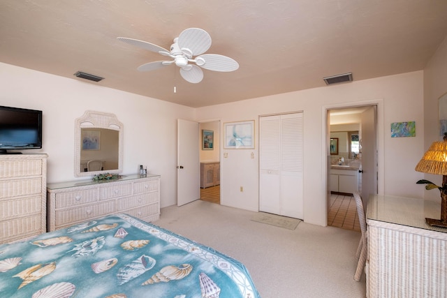 bedroom with connected bathroom, sink, ceiling fan, light carpet, and a closet