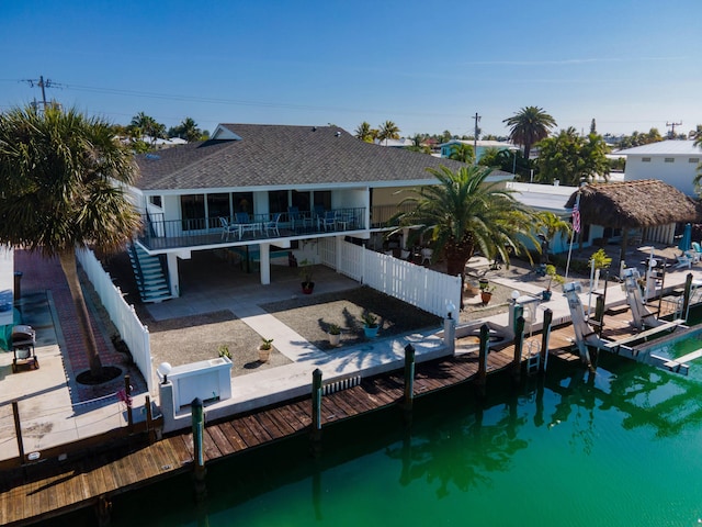 back of property with stairs, roof with shingles, a patio area, and a fenced backyard