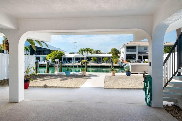 view of patio with a dock and a water view