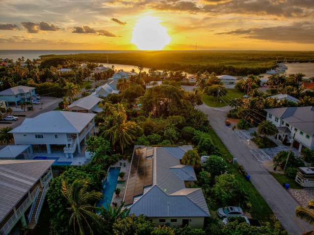 aerial view at dusk featuring a water view